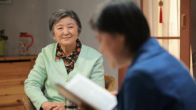 Una cristiana cattolica sta ascoltando una sorella chi sta leggendo la parola di Dio